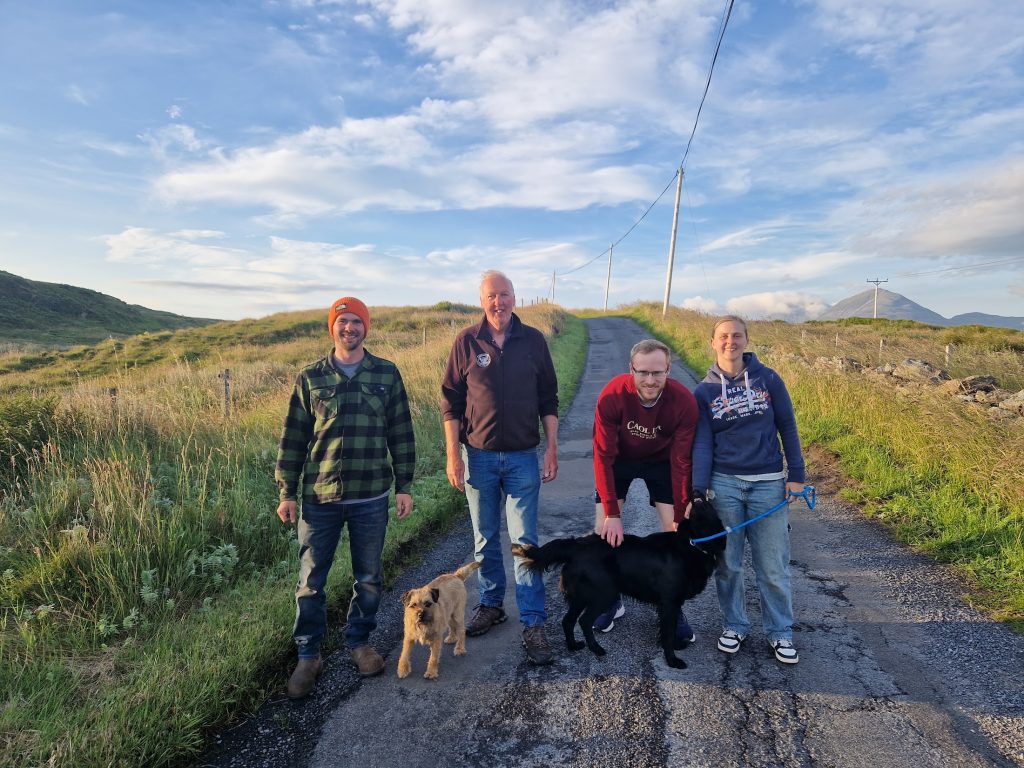 A group of four people on the road with two dogs