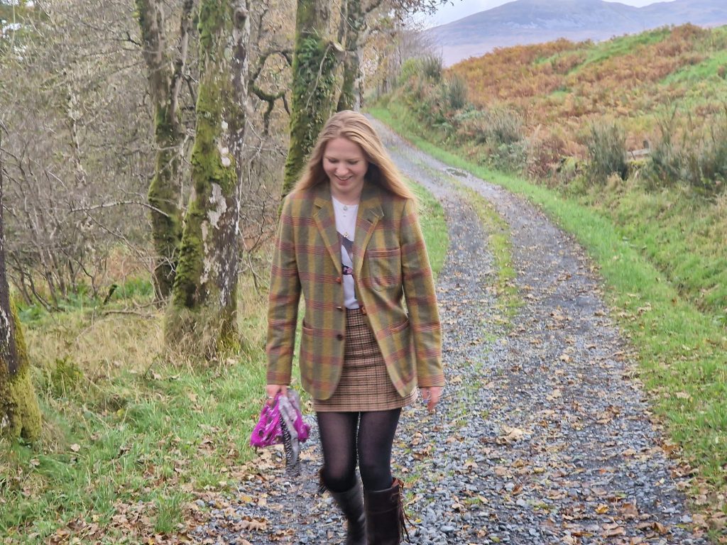 Girl smiling as she walks along a track beside trees