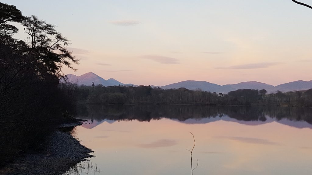 Sunset across the loch with hills in background