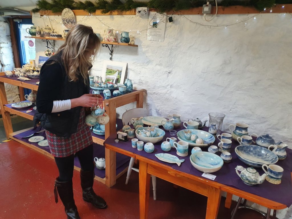 A girl standing beside a table filled with plates and bowls