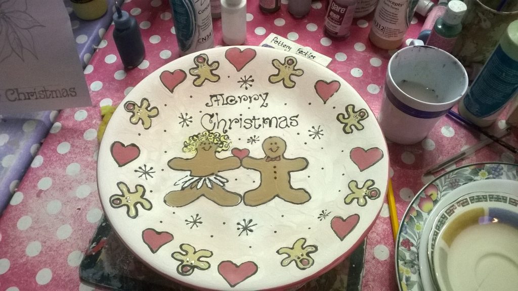 A plate with gingerbread men painted on and a border of hearts and gingerbread men