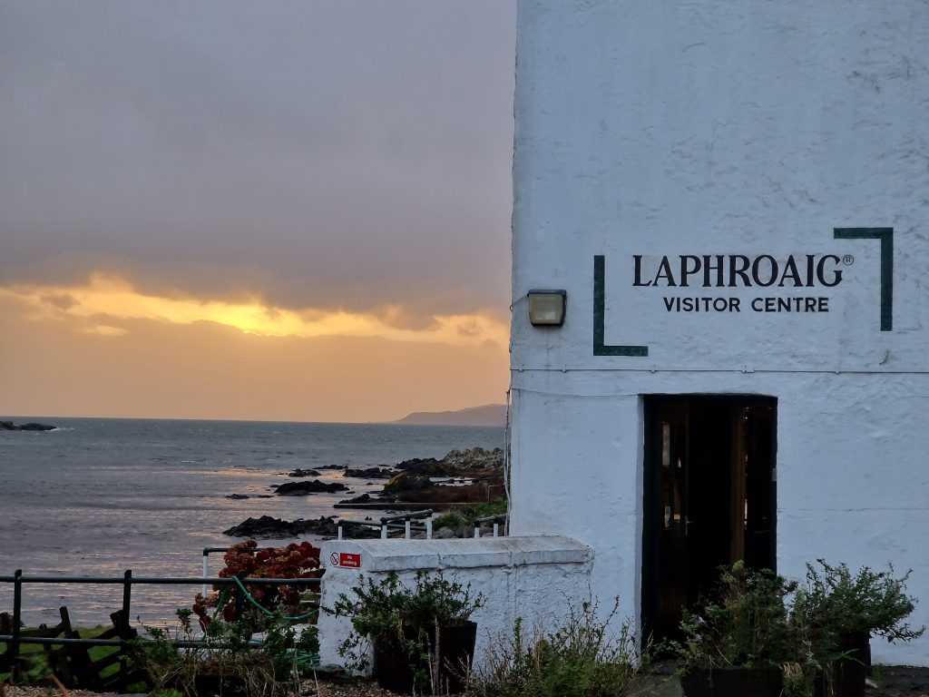 The sea and a white building with a sign saying Laphroaig