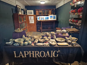 A table with ceramics on it and art prints in the background