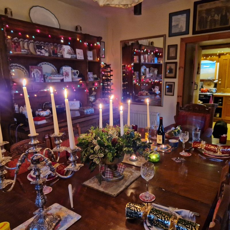 Table with candles on a candelabra. Placemats. A dresser in the background